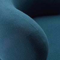 Teal, textured fabric detail of a chair arm, featuring a soft, plush finish and smooth stitching.