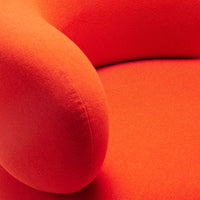 Vibrant orange textured fabric showcasing a smooth, rounded armrest and seat cushion. Perfect for modern decor.
