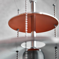Copper and silver chandelier with circular shades and intricate bead detailing, showcasing a modern design.