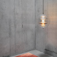 Modern pendant light featuring a clear globe design, warm yellow glow, and minimalist gray concrete backdrop.