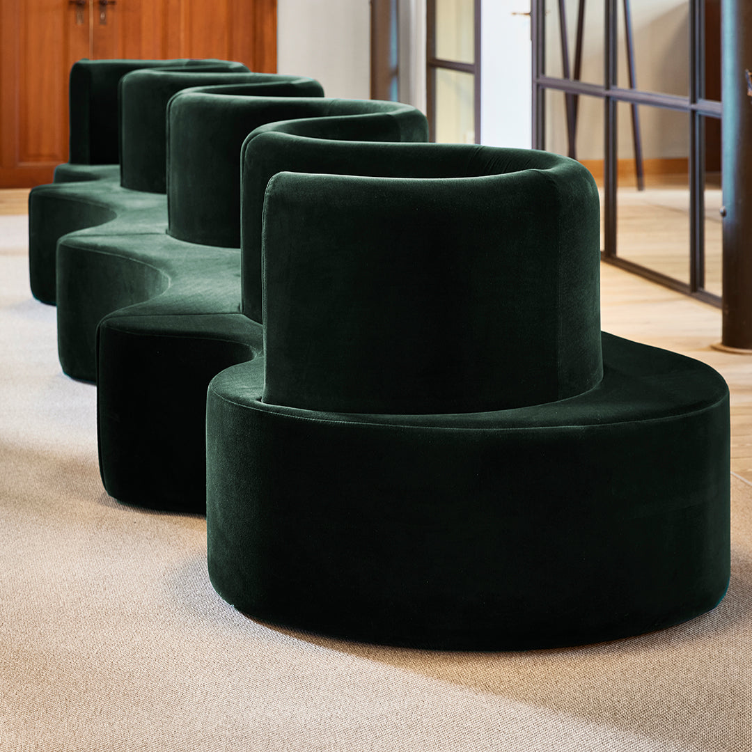 Green velvet sculptural seating with smooth, rounded forms and modern, organic design.