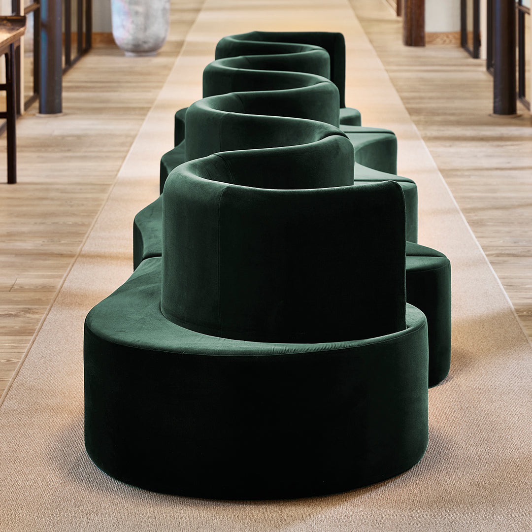 Dark green velvet seating with a spiral pattern, creating a modern and stylish look for any space.
