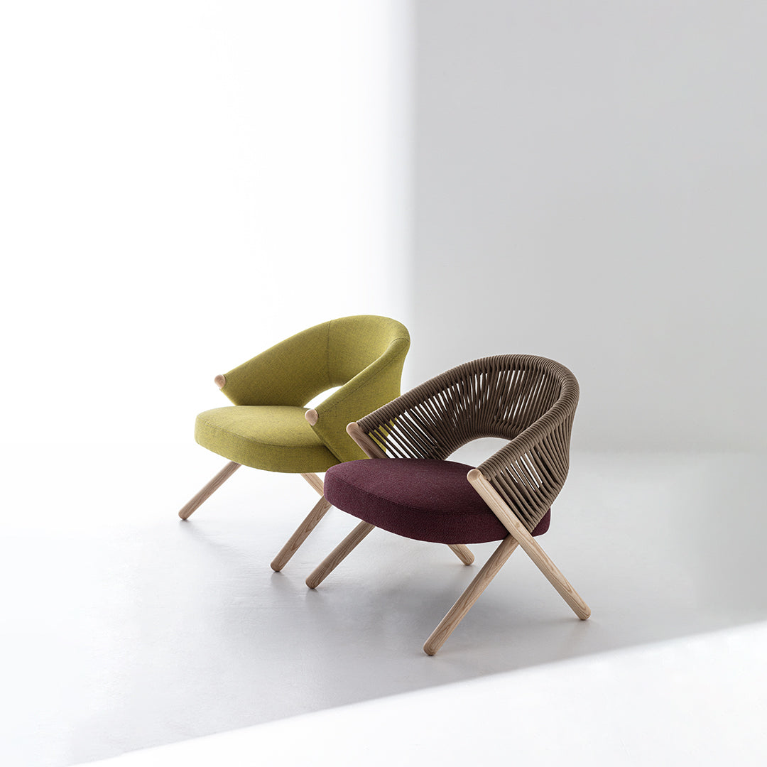 Two modern chairs featuring a vibrant green and rich burgundy upholstery with unique wooden frames and cross legs.