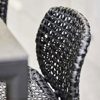 Black woven chair with intricate pattern for a stylish, modern look. Perfect for indoor or outdoor settings.