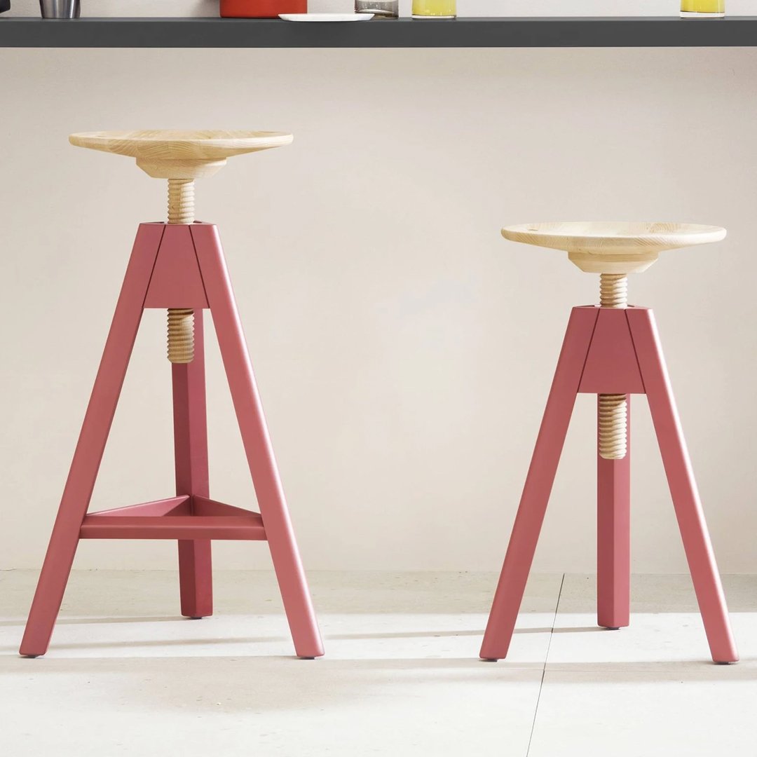 "Wooden stools with natural wood tops and pink bases, featuring a minimalist design and modern aesthetic."