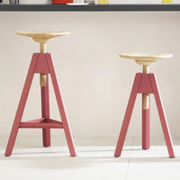 "Wooden stools with natural wood tops and pink bases, featuring a minimalist design and modern aesthetic."
