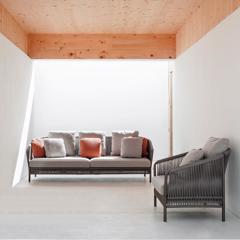 Stylish sofa set with neutral cushions in gray and white, accented by terracotta throw pillows. Modern minimalist design.