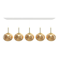 Gold and transparent glass pendant lights with a swirling pattern, mounted on a sleek white fixture.