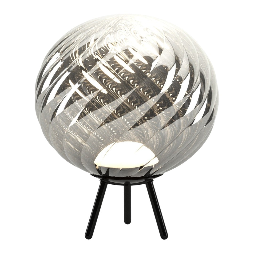Glass lamp with swirling black and white patterns, featuring a sleek black tripod base.
