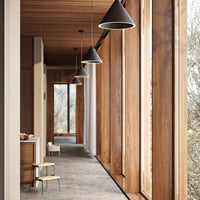 Modern interior with warm wood tones, sleek gray flooring, and black pendant lights. Stylish and inviting atmosphere.