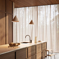 Modern kitchen featuring soft beige curtains, warm wood tones, and muted earth colors in cabinetry and decor.