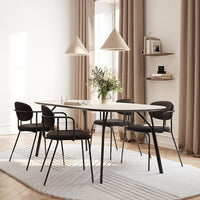 Modern dining set featuring soft beige curtains, sleek black chairs, and a light gray patterned rug.