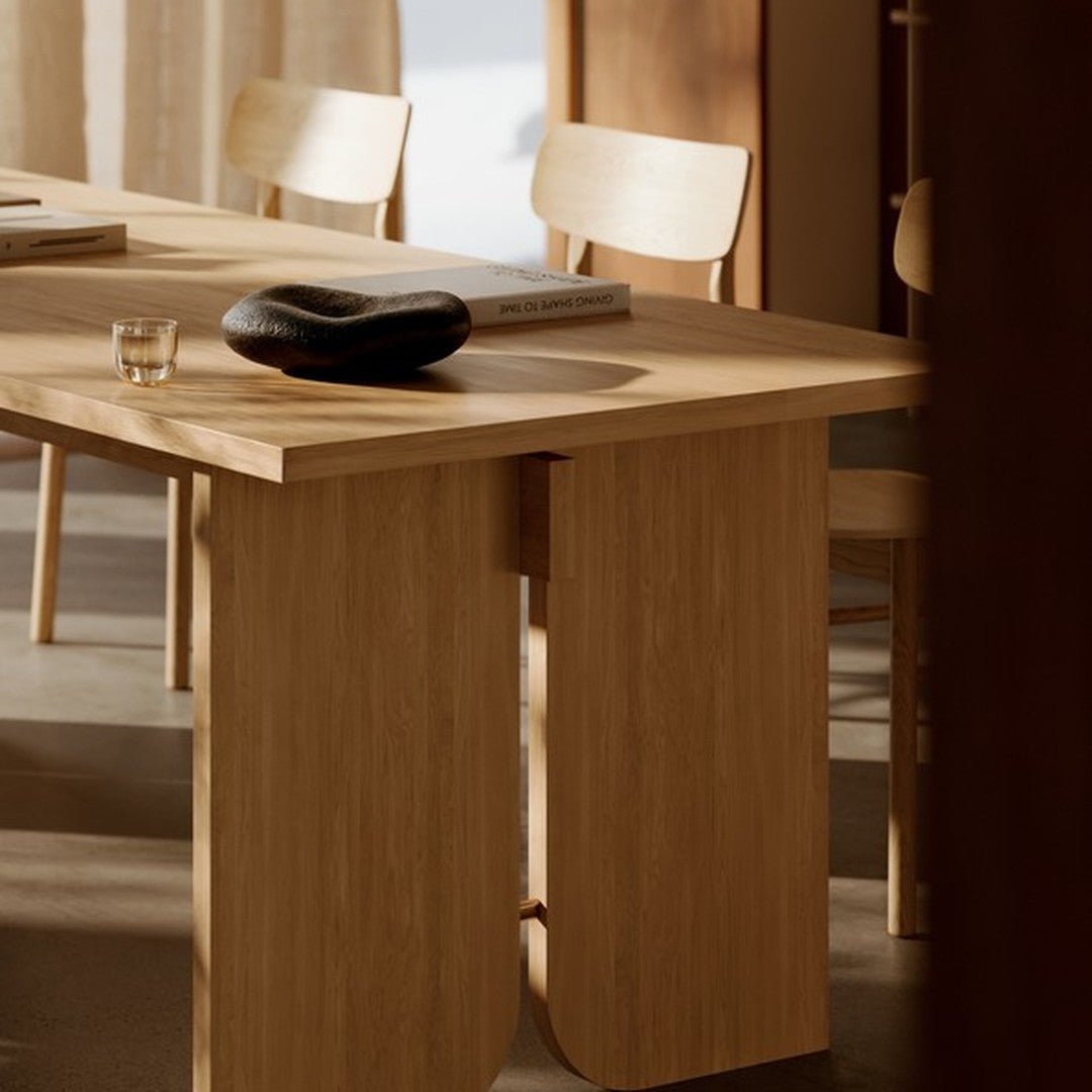 Natural wood tones, smooth surfaces, and earthy colors create a warm, minimalistic dining table aesthetic.
