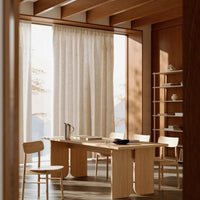 Light beige curtains, natural wood furniture, and warm brown accents create a serene, modern interior.