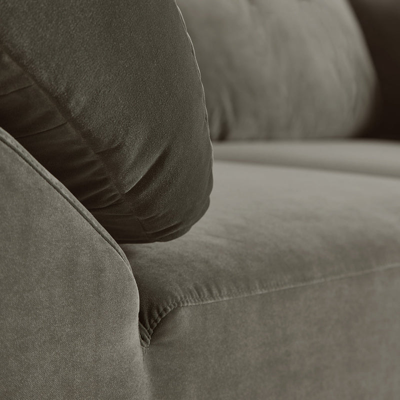 Soft, dark green velvet couch with plush cushions and smooth fabric, ideal for modern living spaces.