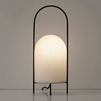Black metal lamp with a ribbed white glass shade, creating a modern and minimalist aesthetic.