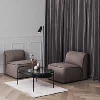 Gray velvet curtains, light gray chairs with dark piping, and a sleek black marble coffee table on a soft white rug.