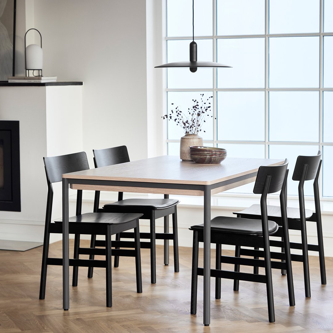 Modern black and white dining table set with a sleek wood finish and minimalist design, highlighting clean lines and textures.