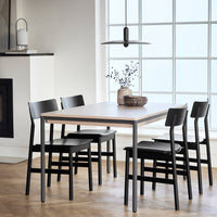 Modern black and white dining table set with a sleek wood finish and minimalist design, highlighting clean lines and textures.