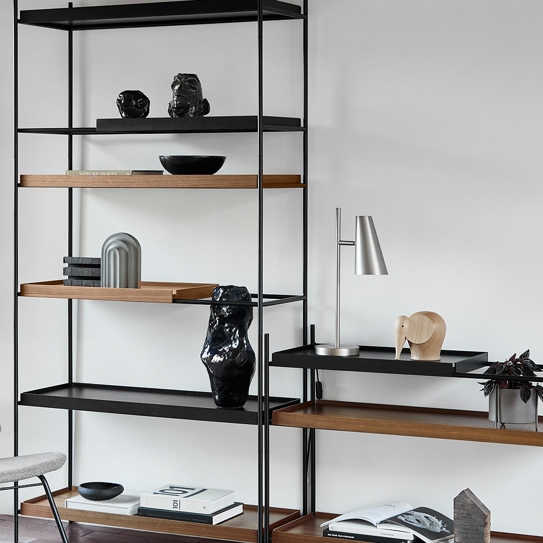 Modern black and wood shelf with decorative objects, featuring sleek lines and minimalist design.
