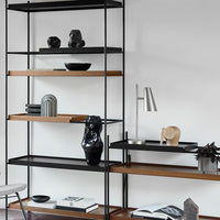 Modern black and wood shelf with decorative objects, featuring sleek lines and minimalist design.