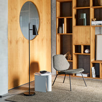 "Modern gray chair with a textured fabric, surrounded by warm wood tones and minimalist decor in a sleek interior."