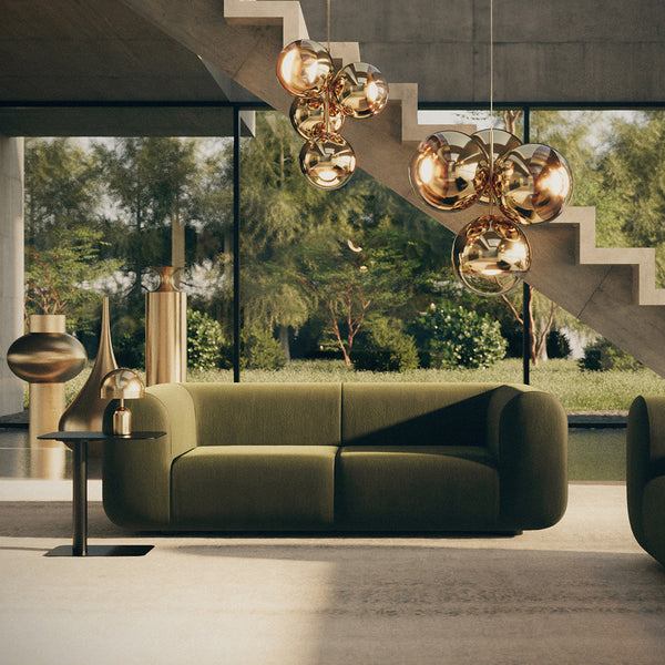 Modern green sofa with geometric patterns, gold accents, and soft textures in a stylish interior setting.