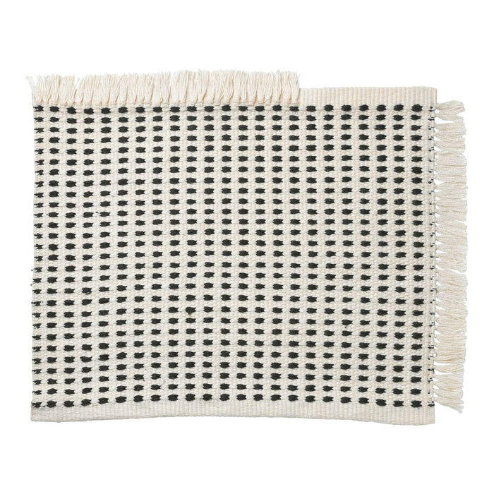 Woven cream placemat featuring a black square pattern with fringed edges for a chic, modern look.