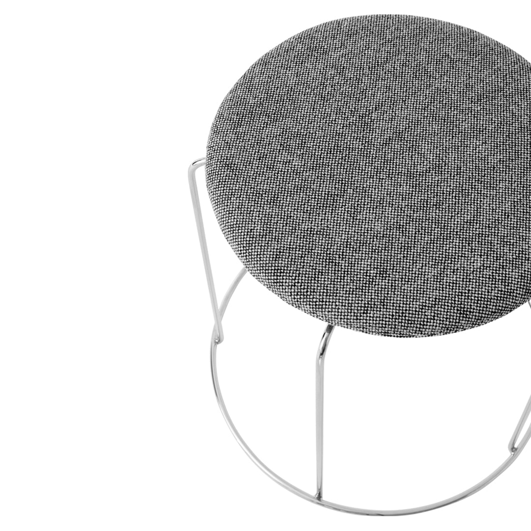 Gray textured upholstery on a round stool with a minimalist white metal base.