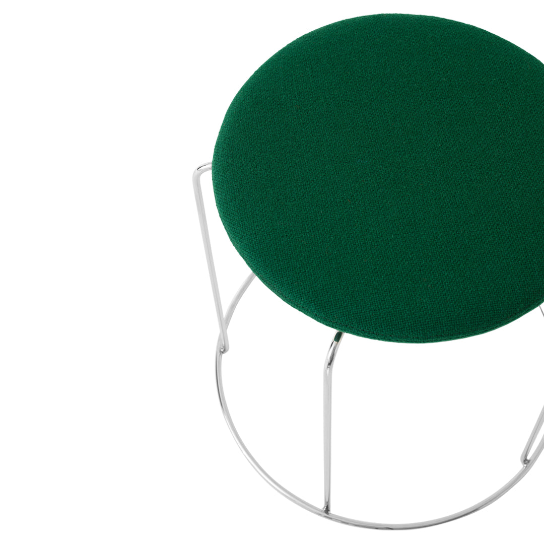 Green circular cushion with a textured surface, set on a sleek metal frame. Ideal for modern decor.