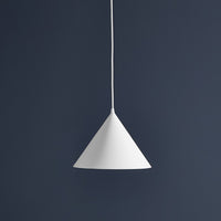 White cone pendant light against a dark blue wall, showcasing a minimalist design and sleek color contrast.