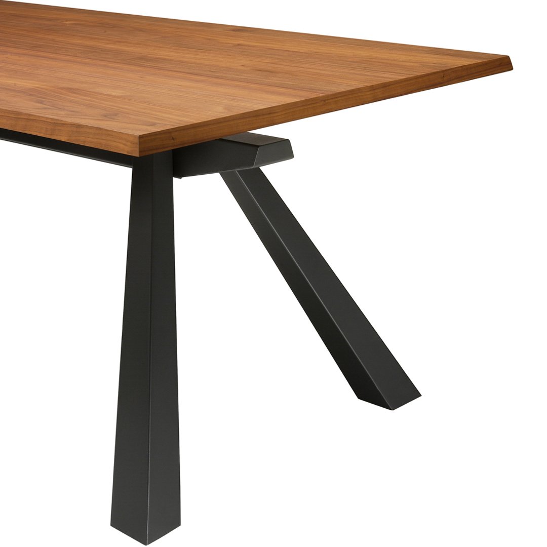 "Natural wood tabletop with rich honey tones, paired with sleek black angular metal legs."