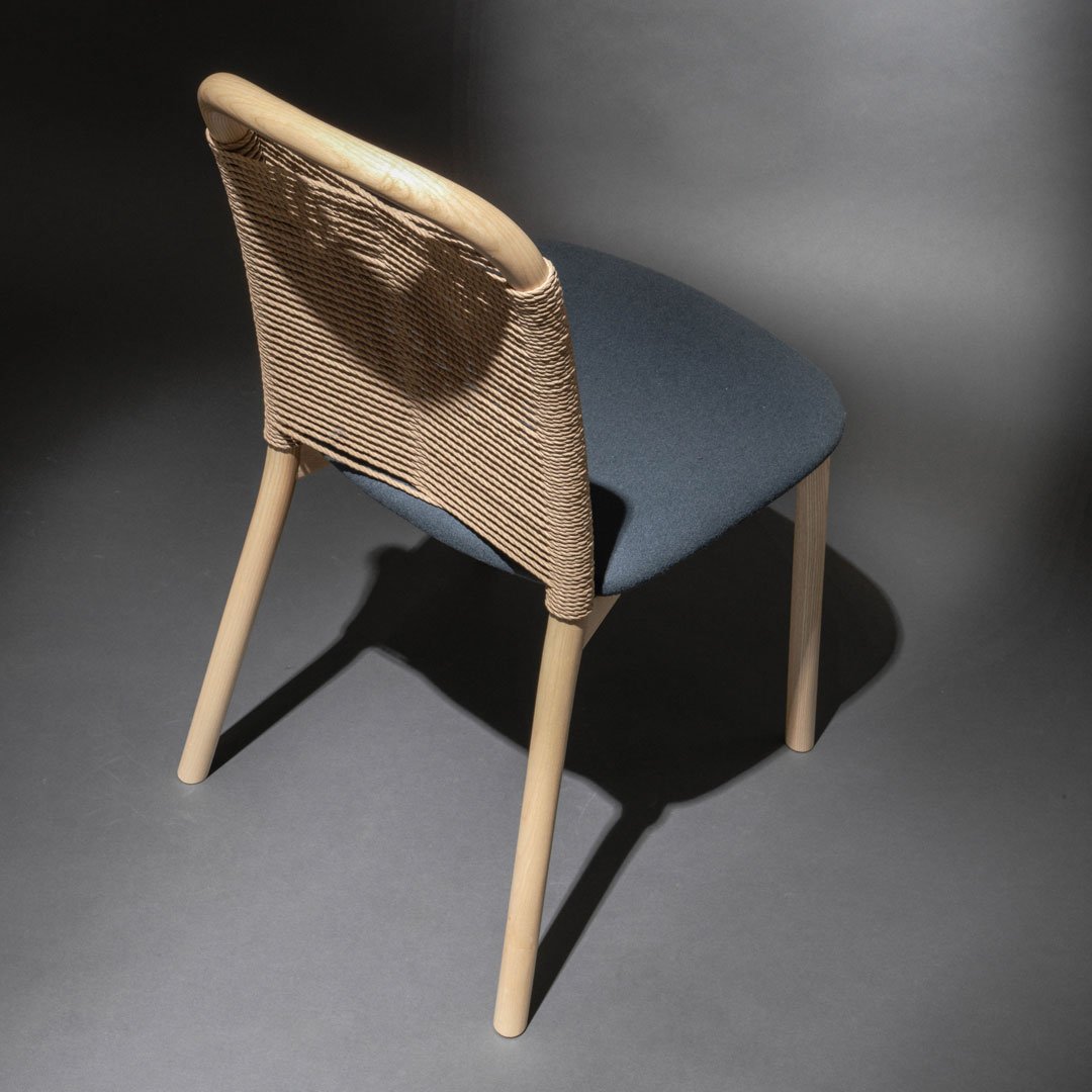 Light blue seat with a woven natural rattan backrest and wooden legs, showcasing a modern, minimalist design.