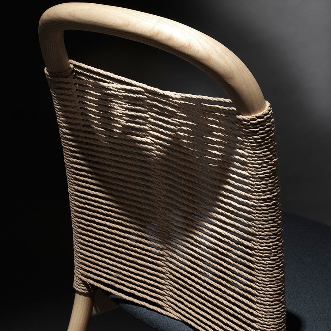Light beige woven pattern on a chair backrest against a dark backdrop, showcasing modern design and texture.