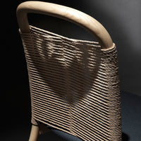 Light beige woven pattern on a chair backrest against a dark backdrop, showcasing modern design and texture.