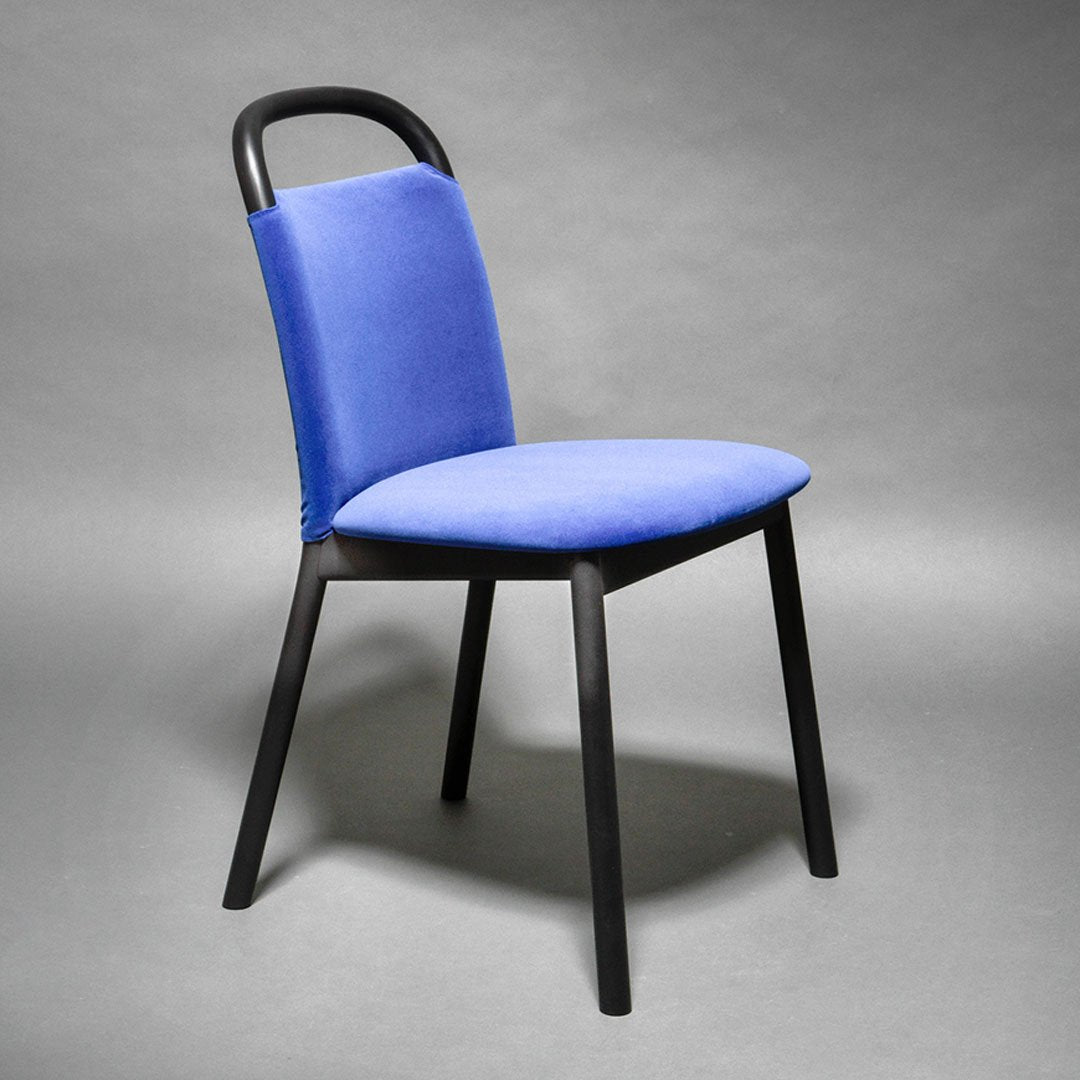 Blue upholstered dining chair with a sleek black frame, featuring a minimalist design and a smooth texture.