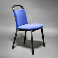 Blue upholstered dining chair with a sleek black frame, featuring a minimalist design and a smooth texture.