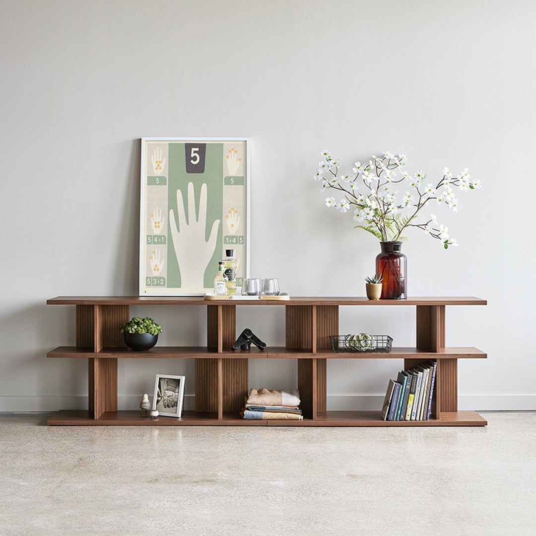 Wooden shelf with a rich brown finish, simple geometric patterns, paired with a green and cream artwork.