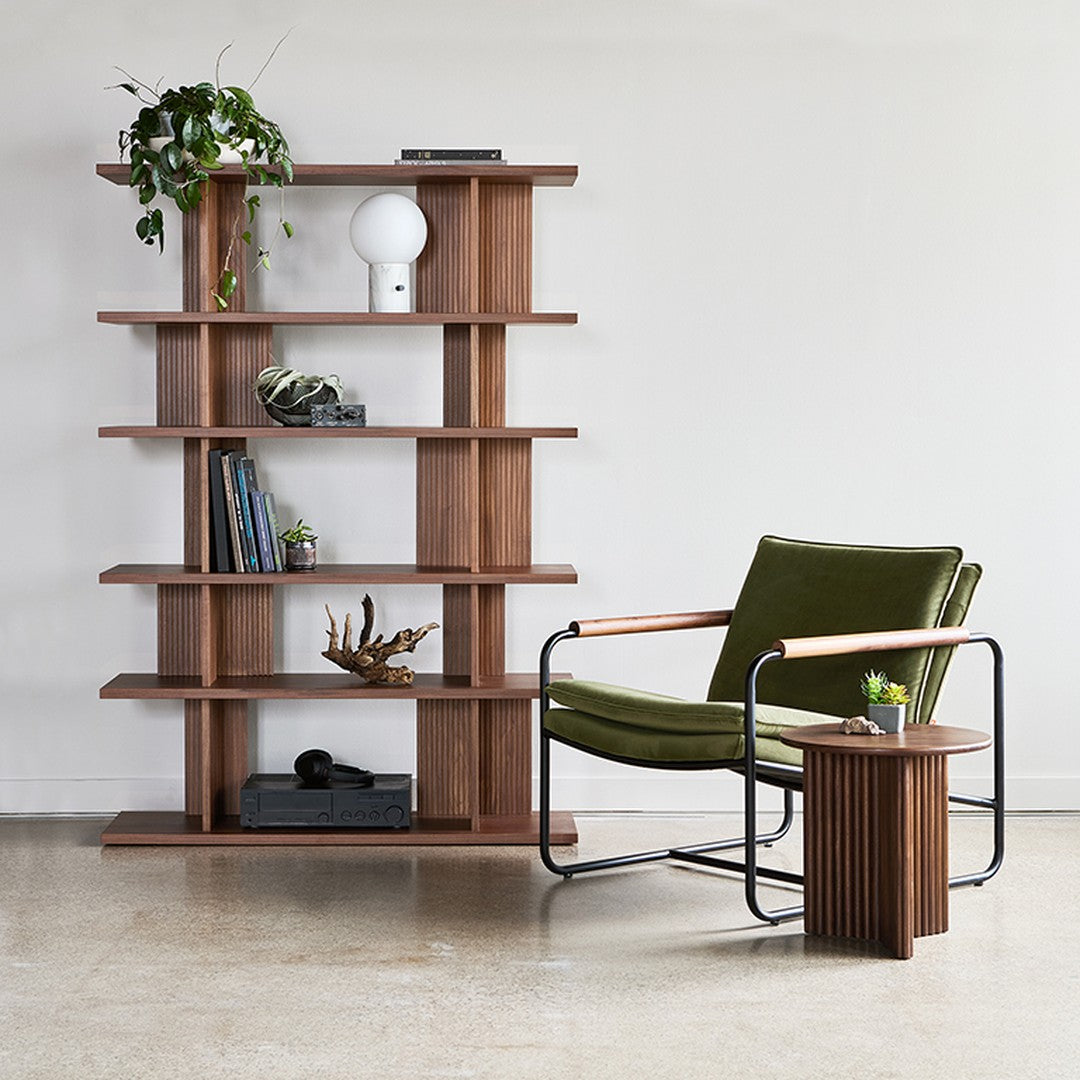 Modern wooden shelving unit with rich brown tones, paired with a sleek green chair and minimalistic accents.