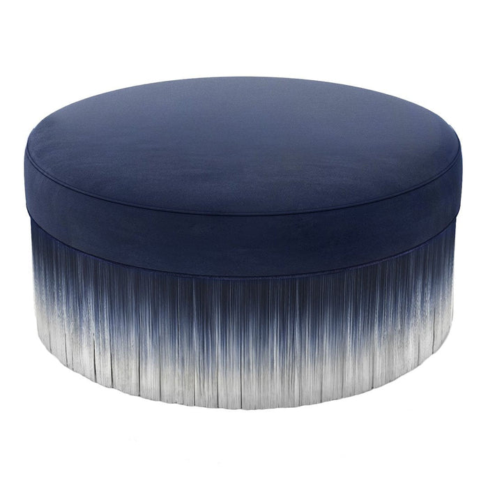 Navy blue round ottoman with a gradient pattern, featuring a fringed finish that transitions from dark to light shades.