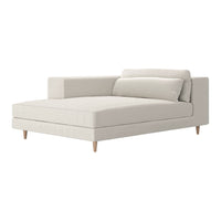 Soft beige chaise lounge with minimalist design and light wooden legs, featuring smooth, textured upholstery.