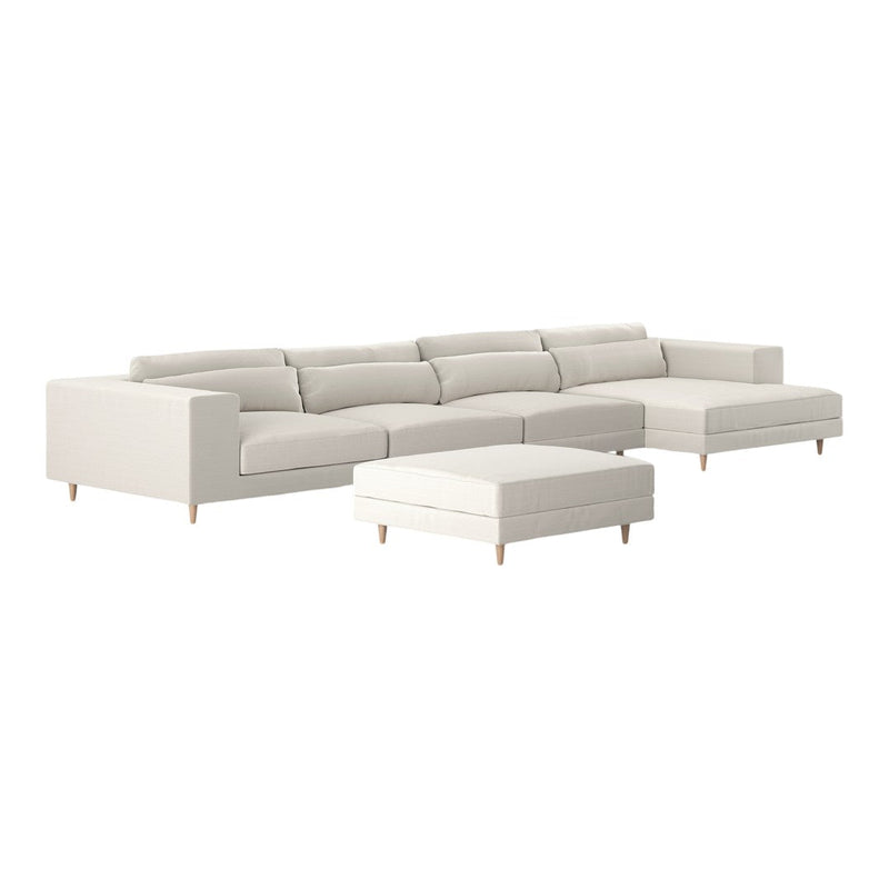 Light beige sectional sofa with minimalist design and matching ottoman, featuring muted solid color upholstery.