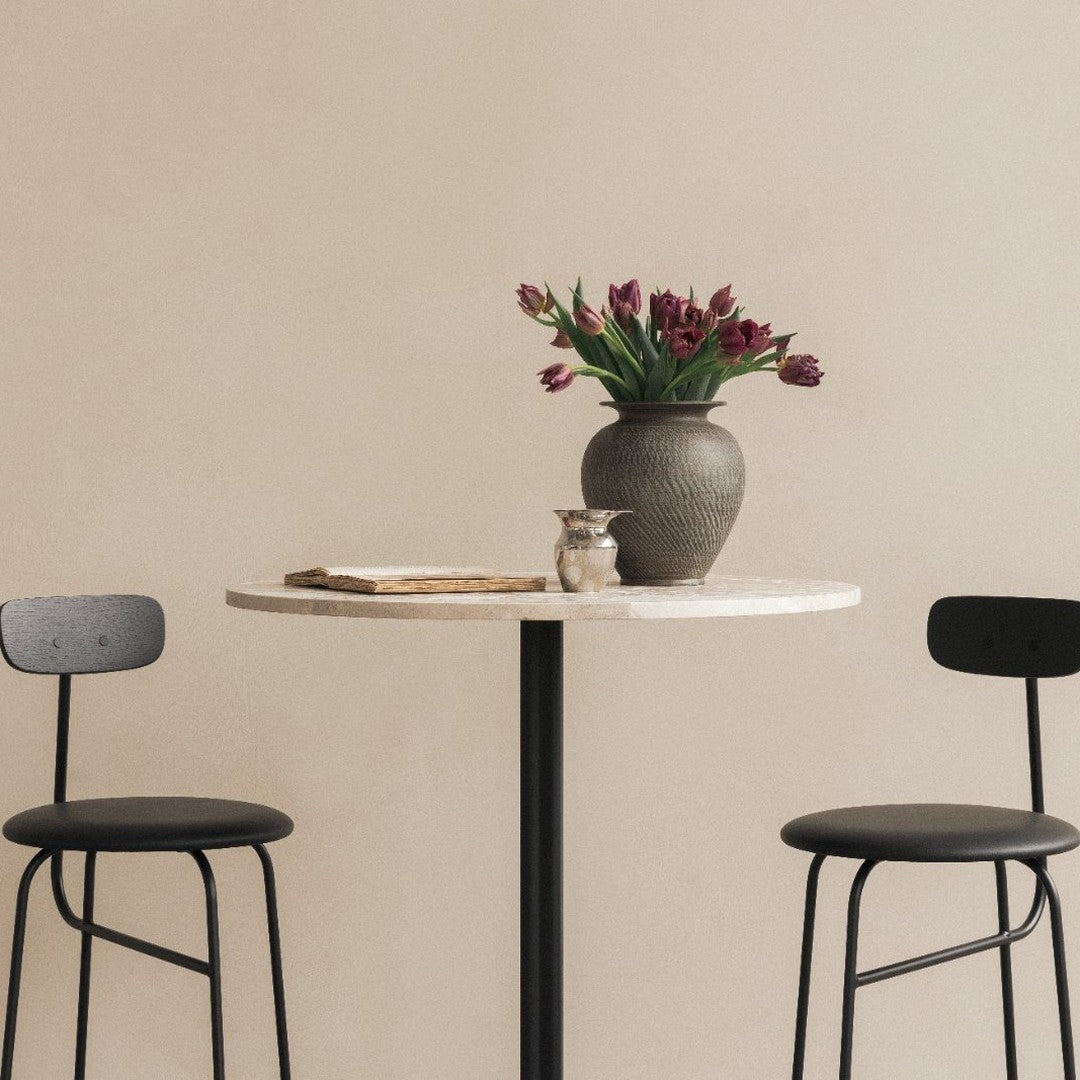 Modern black and white table with minimalist design, featuring a gray vase and vibrant purple tulips.