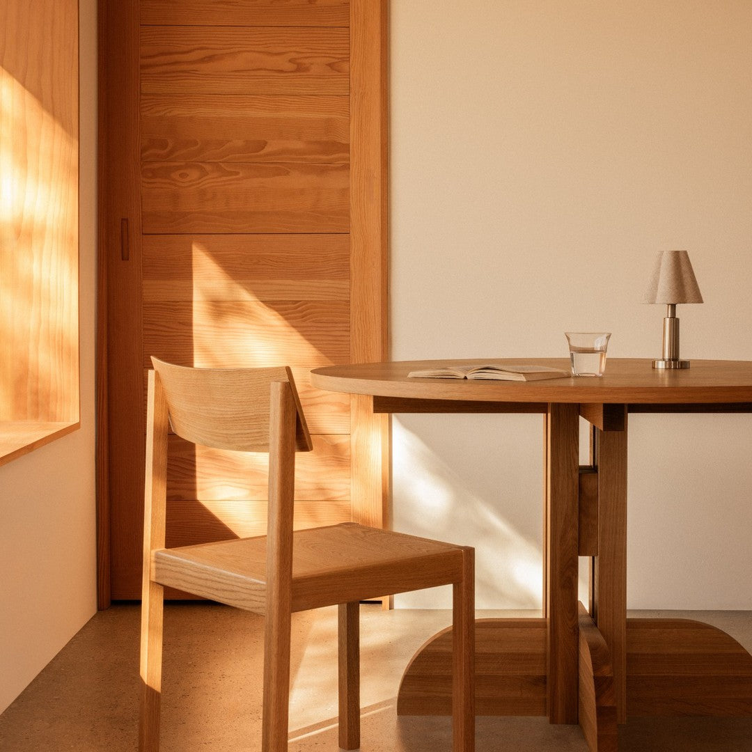 Light wood dining table and chair with warm, natural tones and sleek, minimalistic design in a modern setting.