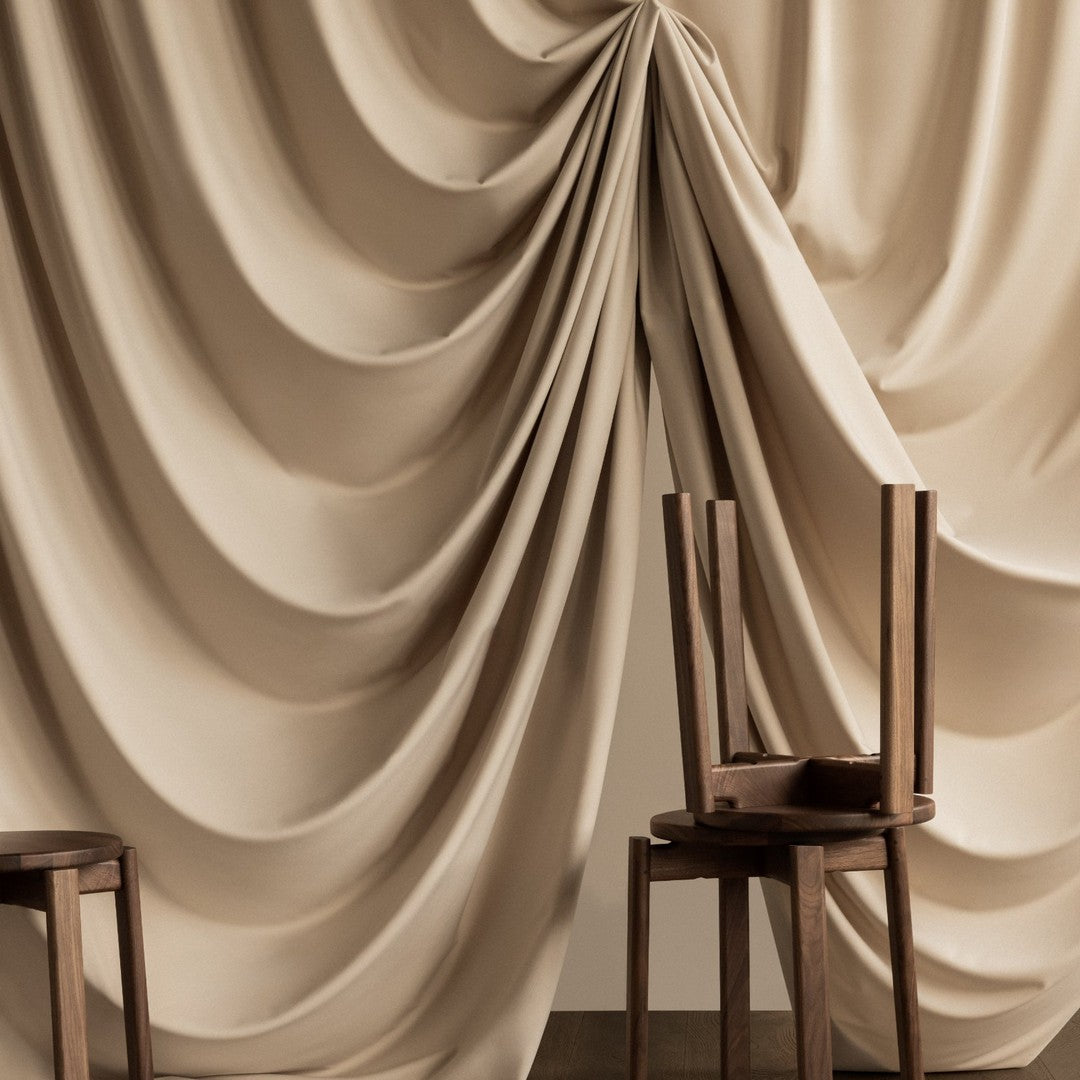 Elegant beige draped fabric with soft, flowing patterns, complemented by minimalist wooden chairs.