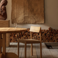 Natural wood tones with textured beige wall art; serene, earthy palette in a cozy interior setting.
