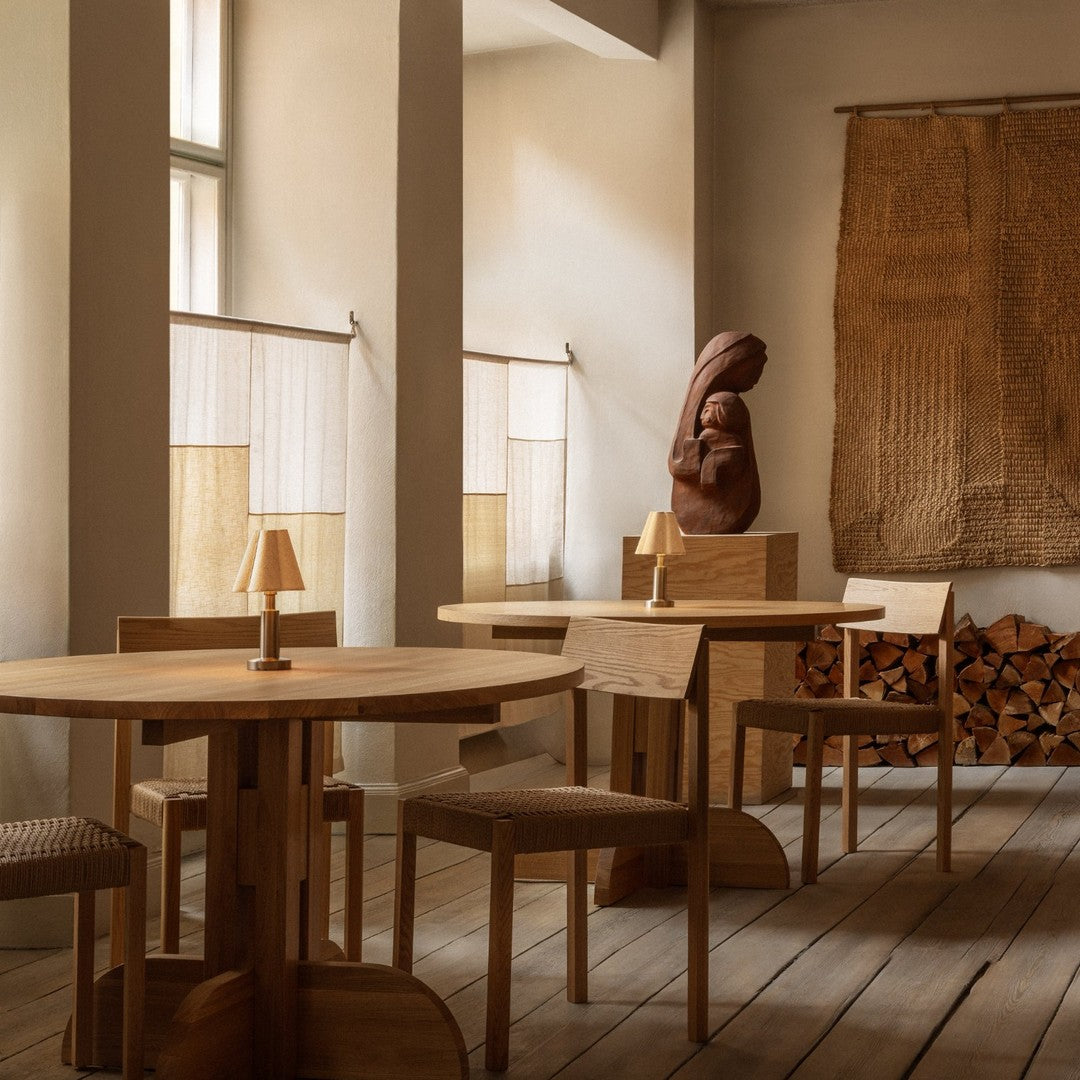Warm wood tones, minimalist design, and natural textures create a cozy ambiance in a stylish indoor setting.