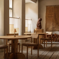 Warm wood tones, minimalist design, and natural textures create a cozy ambiance in a stylish indoor setting.