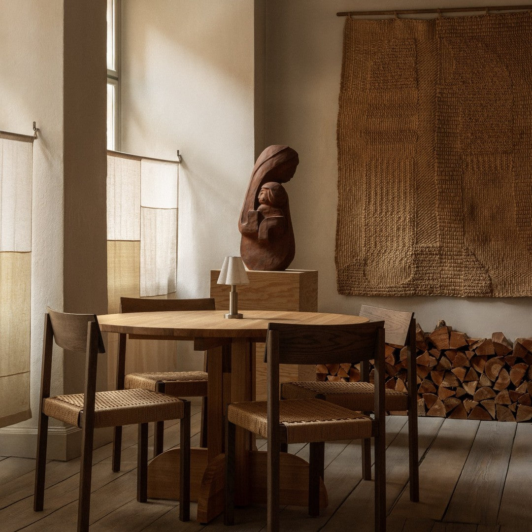 Warm earthy tones with textured patterns on wall hangings and wooden furniture create a cozy ambiance.