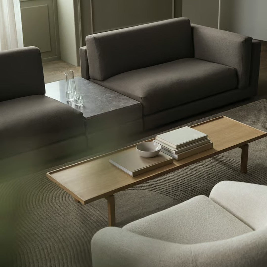 Neutral gray and cream sofa set with a light wood coffee table and subtle textured area rug. Modern minimalist design.